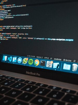Workplace with modern laptop with program code on screen